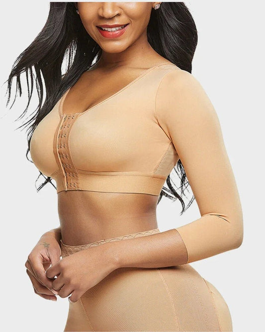 Woman wearing nude long sleeve shapewear top with front hook closure, showing slim fit.