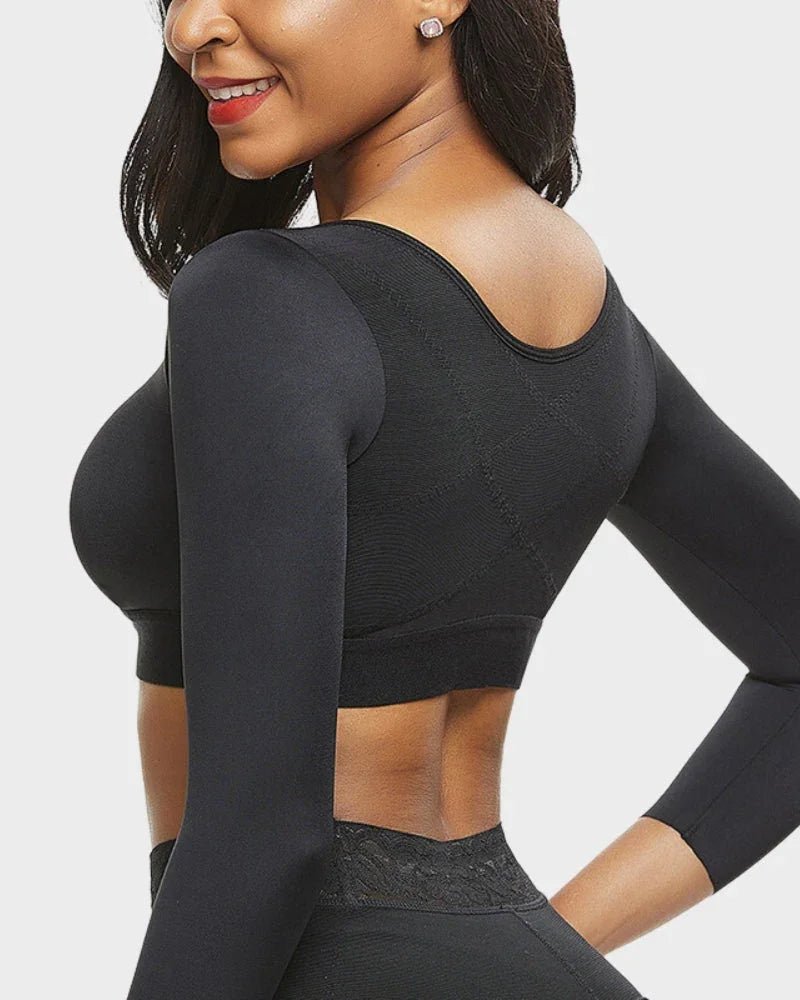 Woman wearing black long-sleeve shapewear crop top, back view, seamless and fitted design.