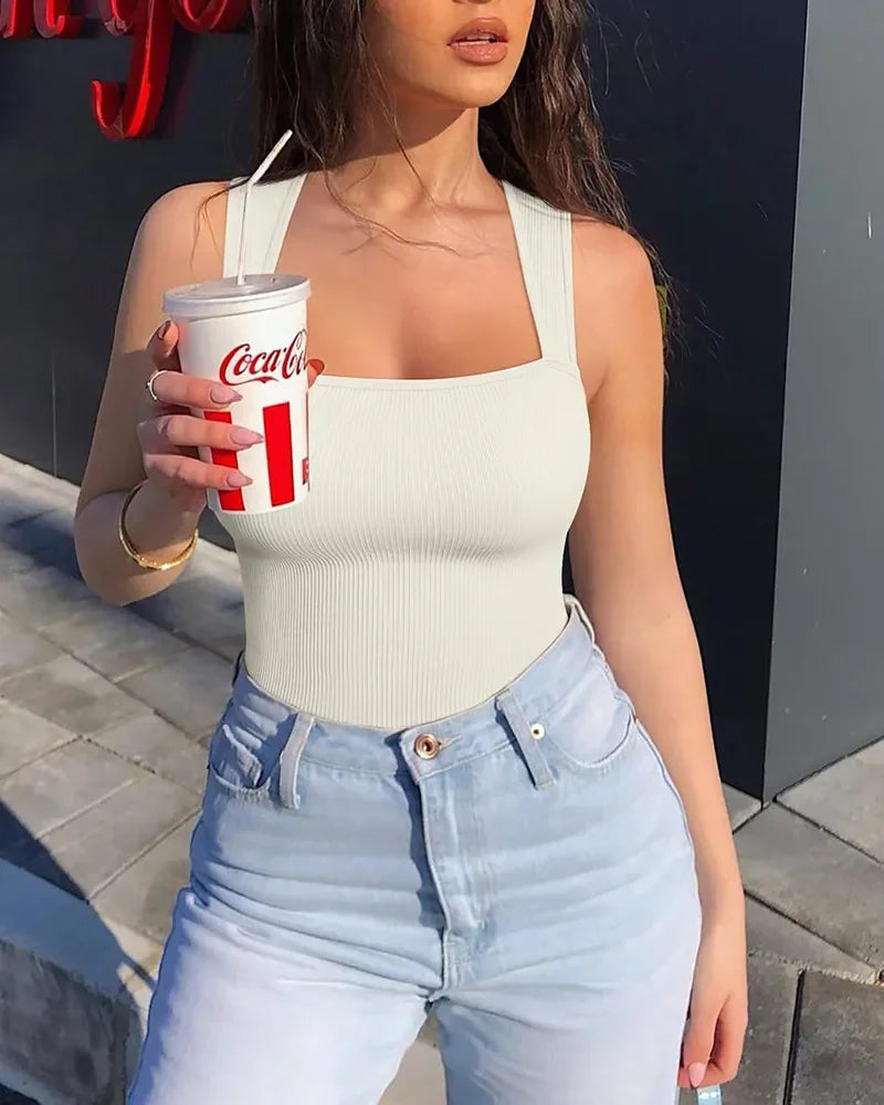 Woman wearing white ribbed shapewear bodysuit and light blue high waist jeans outdoors