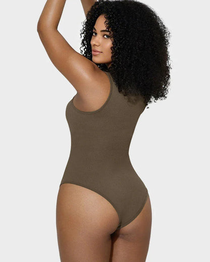Woman in brown seamless shapewear bodysuit posing against a light gray background