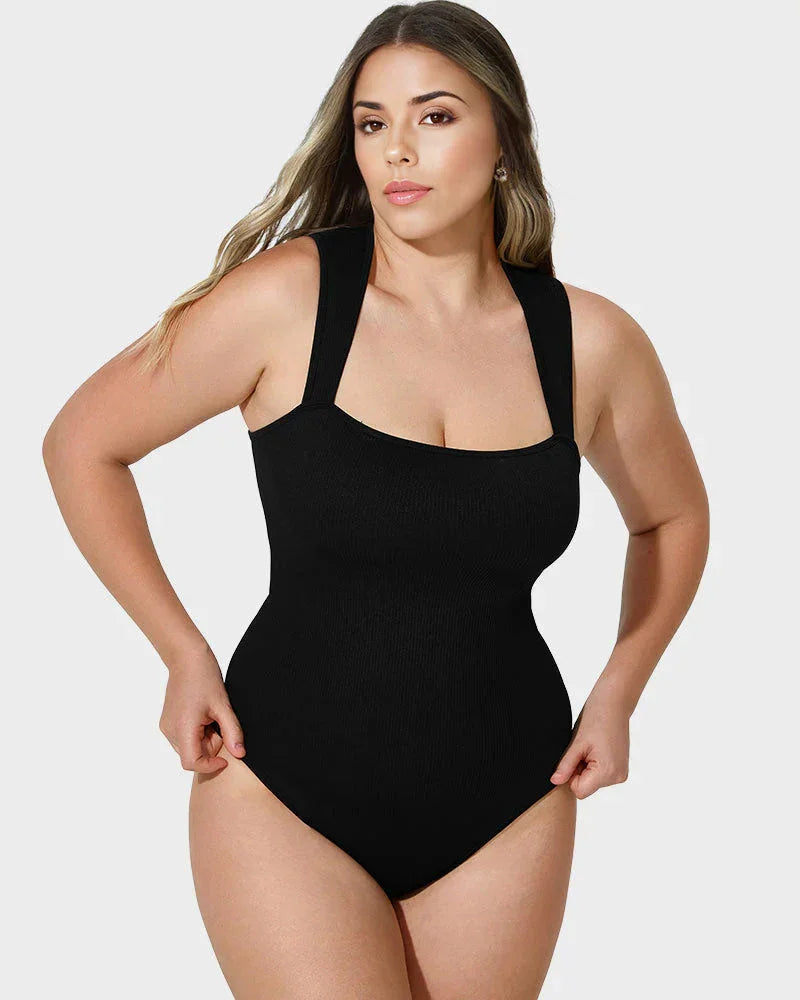 Woman wearing black shapewear bodysuit, showing curve-enhancing fit on light background
