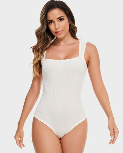 Woman wearing white shapewear bodysuit with wide straps against light background